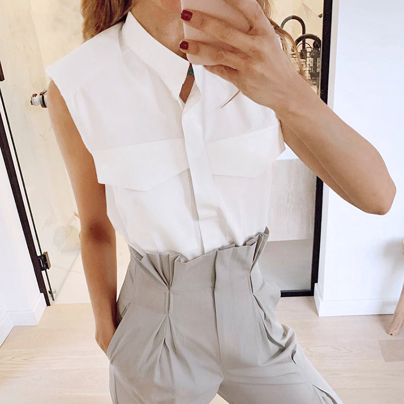 Elegant sleeveless white shirt from M Chic Boutique, featuring a streamlined design and soft fabric for a refined look.