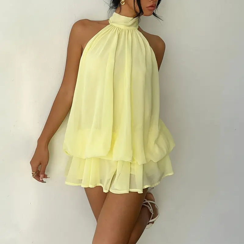 Elegant halter mini dress with bow detail, featuring a fitted silhouette and soft fabric, from M Chic Boutique.